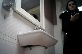 Писающую женщину снимают камерой в туалете