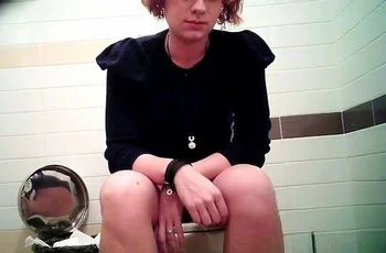 Девушка писает сидя на унитазе общественного туалета