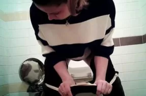Беременная девушка с большим животом писает в туалете