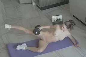 Голая девушка занимается фитнесом дома