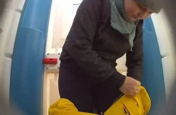 Молодая мама в зимнем комбинезоне посещает туалет